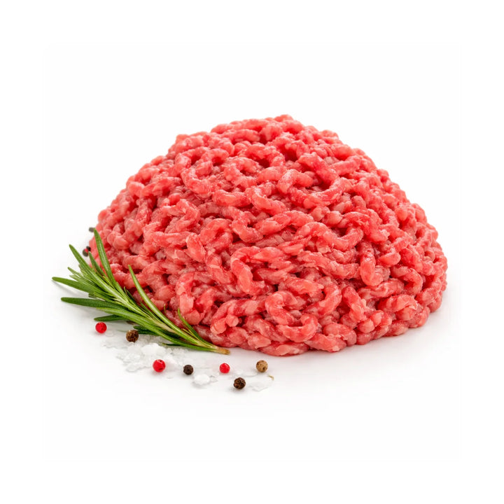 Macinato di bovino Chianina fresco con rosmarino sale grosso e pepe su sfondo bianco