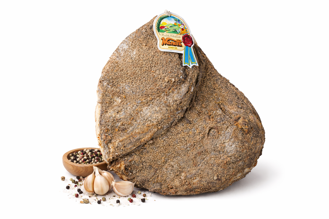 Spalla di maiale stagionata disossata con aglio, pepe in grani e sale su sfondo bianco